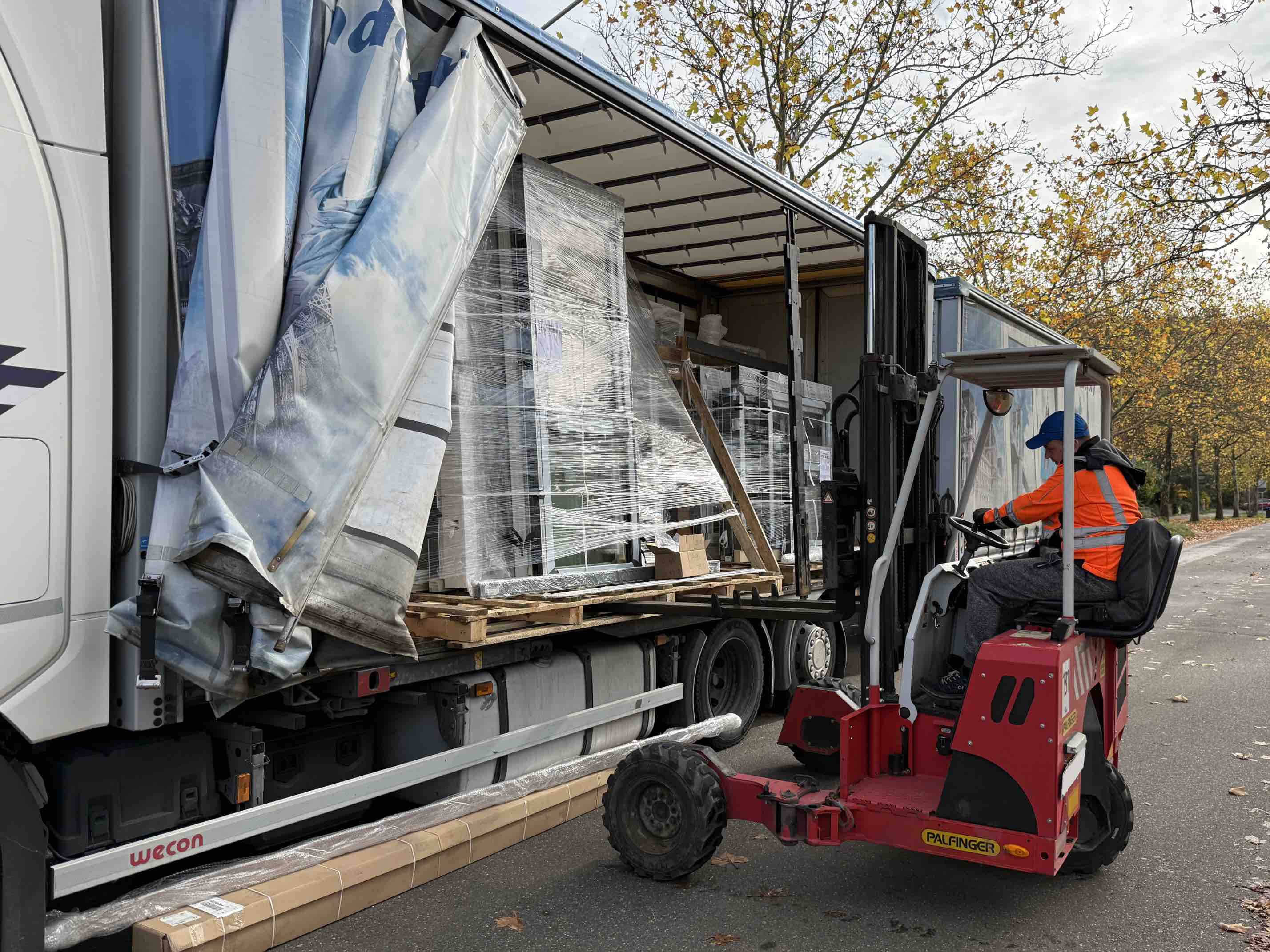 Fenster werden professionell aus dem LKW geladen - Baustelle Anlieferung